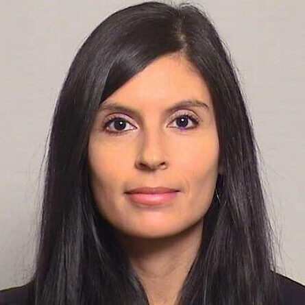 Professional headshot of a woman with long dark hair.